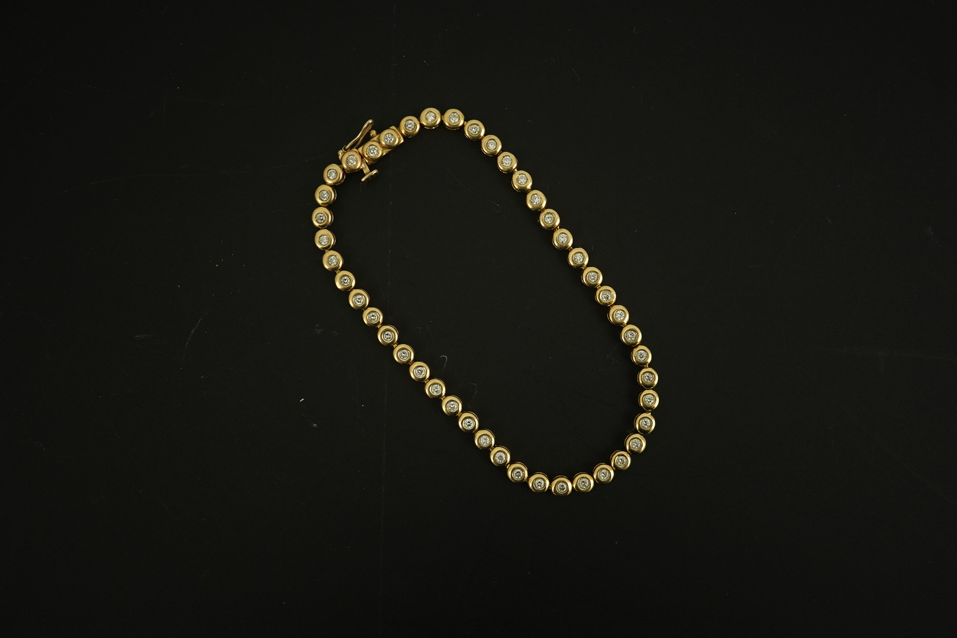 A modern gold and forty five stone round cut diamond set tennis bracelet